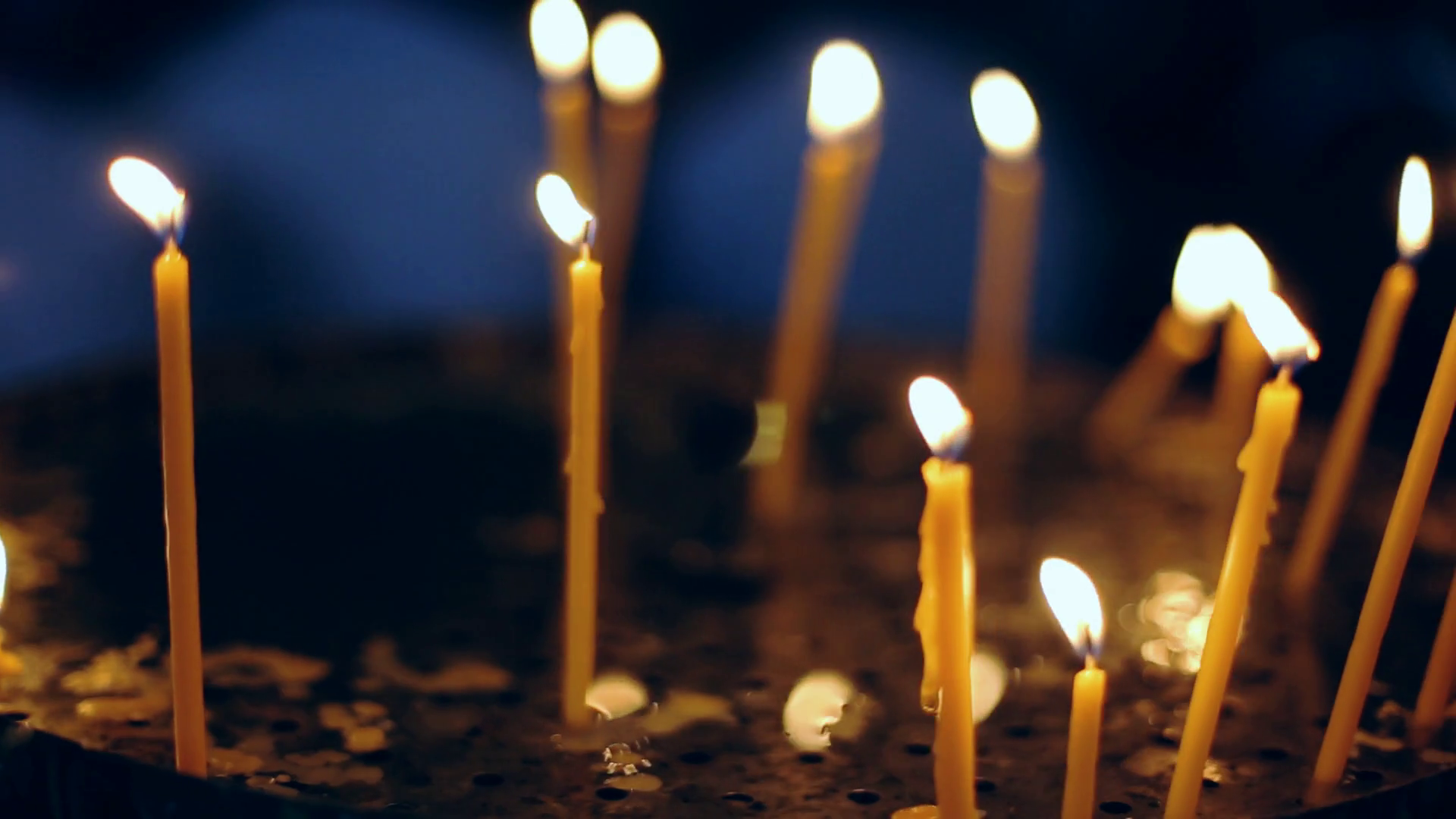 Votive candles burning in a darkened cathedral. Stock Video Footage 00