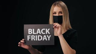 Woman in medical mask showing sign of Black Friday