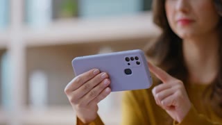 Businesswoman browsing application at mobile phone sitting corporate office closeup. Young woman watching webinar on horizontal cellphone.