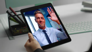 Smiling manager chatting web camera tablet with unrecognizable coworker at office closeup. Happy director telling good news greeting at