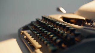 Closeup vintage typewriter with glowing keys in well-lit room. Classic black type equipment standing on white desk under bright sunlight