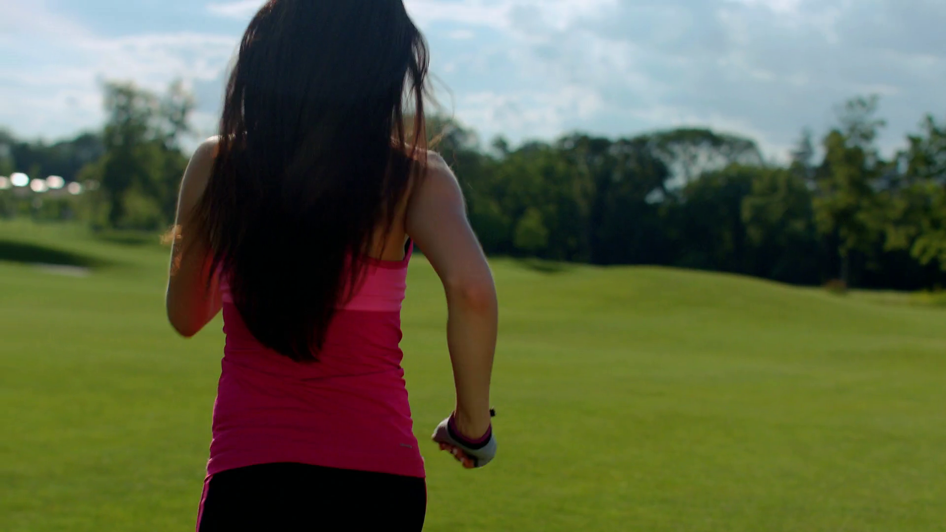 Back of woman running in park. Fit girl running in slow motion. Sport