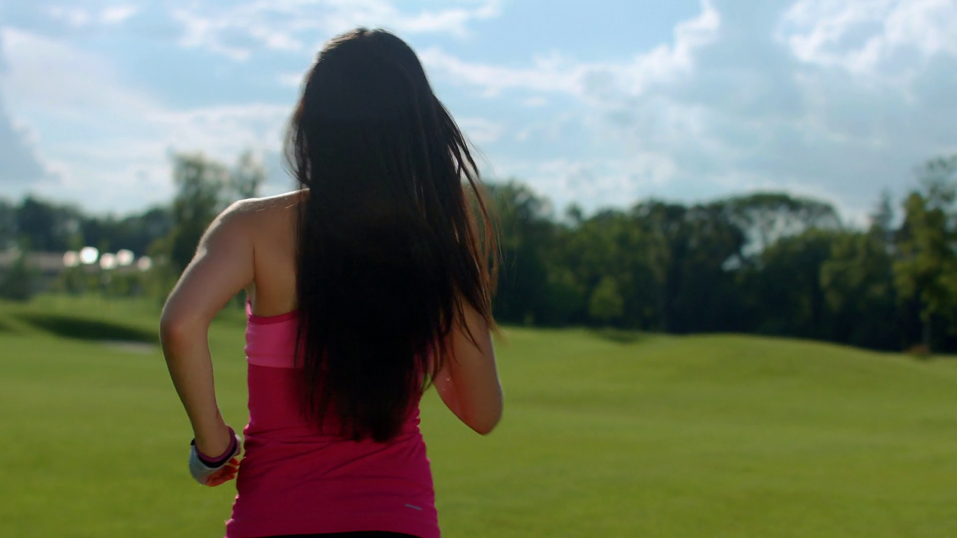 Back of woman running in park. Fit girl running in slow motion. Sport