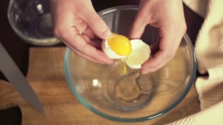 Break egg. Cooking food. Baking ingredients, breaking the eggs, separating yolk from protein. Glass bowl for kneading. Fresh organic eggs falling into bowl. Preparing ingredients for baking cake