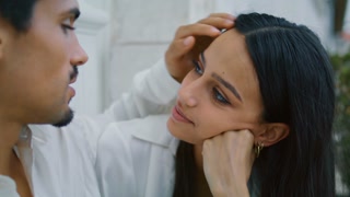 Enamoured man straightening woman hair at street close up. Sensual pair enjoying love moment. Romantic spouses looking at each other at urban place. Gentle guy touching girlfriend with tenderness