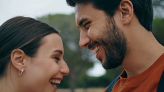 Cheerful smiling couple kissing on nature closeup. Portrait of happy affectionate lovers enjoy romantic date in park. Positive sensual pair feeling love hapiness together. Romance relationship concept