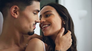 man stroking wife at bedroom close up. Married couple kissing at home portrait. Latina woman flirting with spouse at weekend morning.