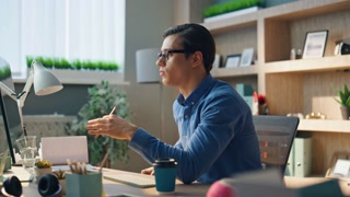Young manager having video conference while sitting in office in front of computer