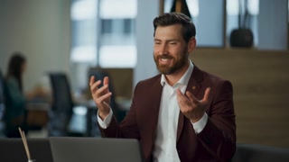 Happy manager talking online negotiation at laptop sitting office closeup. Successful businessman gesturing hands to web camera making call