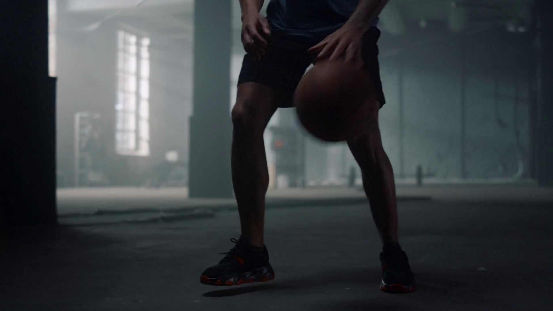 African american man bouncing basketball ball between legs