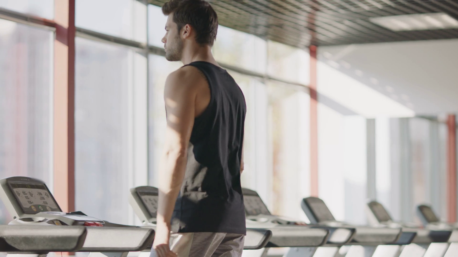 Athlete man walking on treadmill in fitness center. Fitness man
