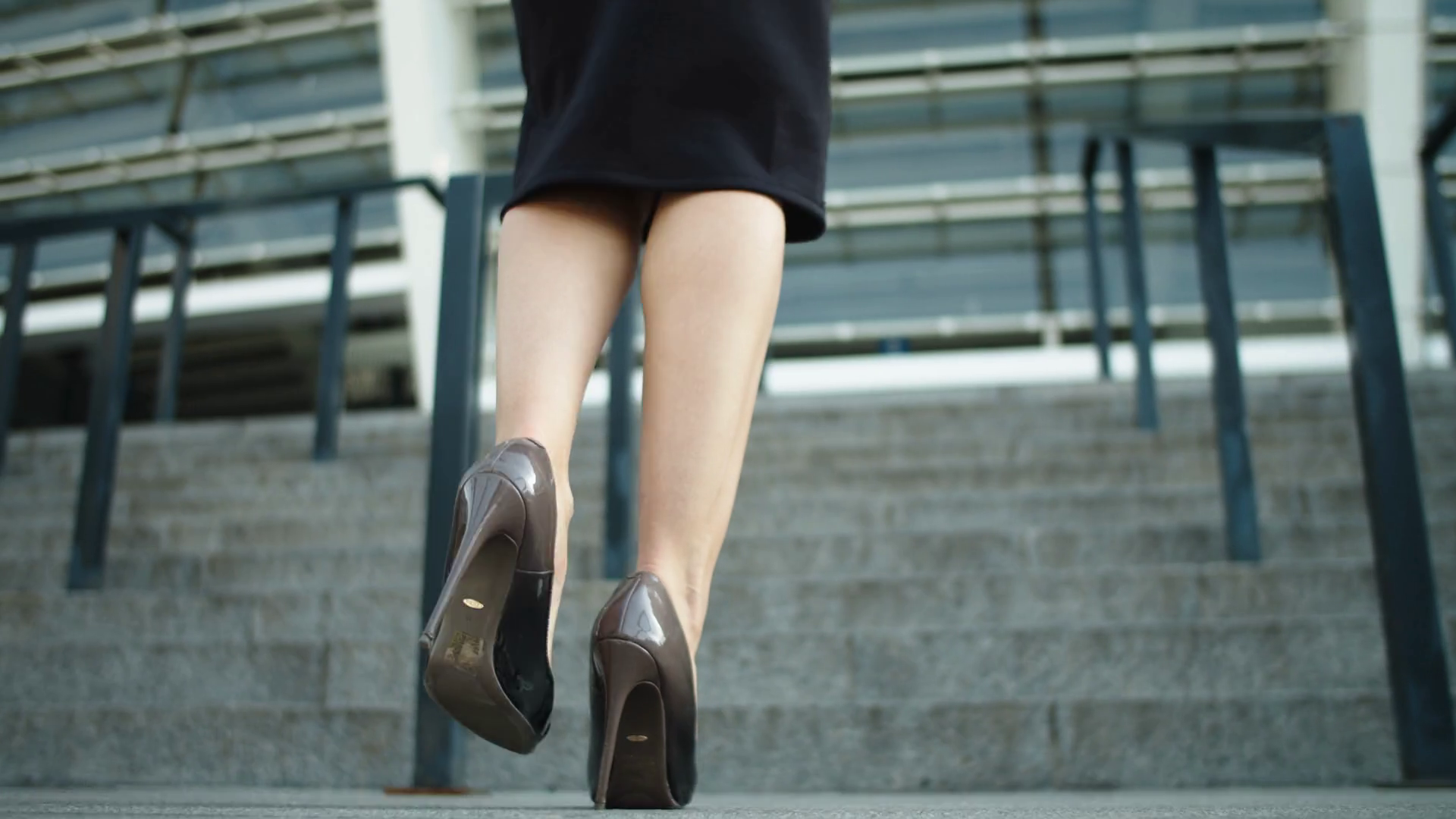 Back view unrecognized woman legs going upstairs at street. Attractive