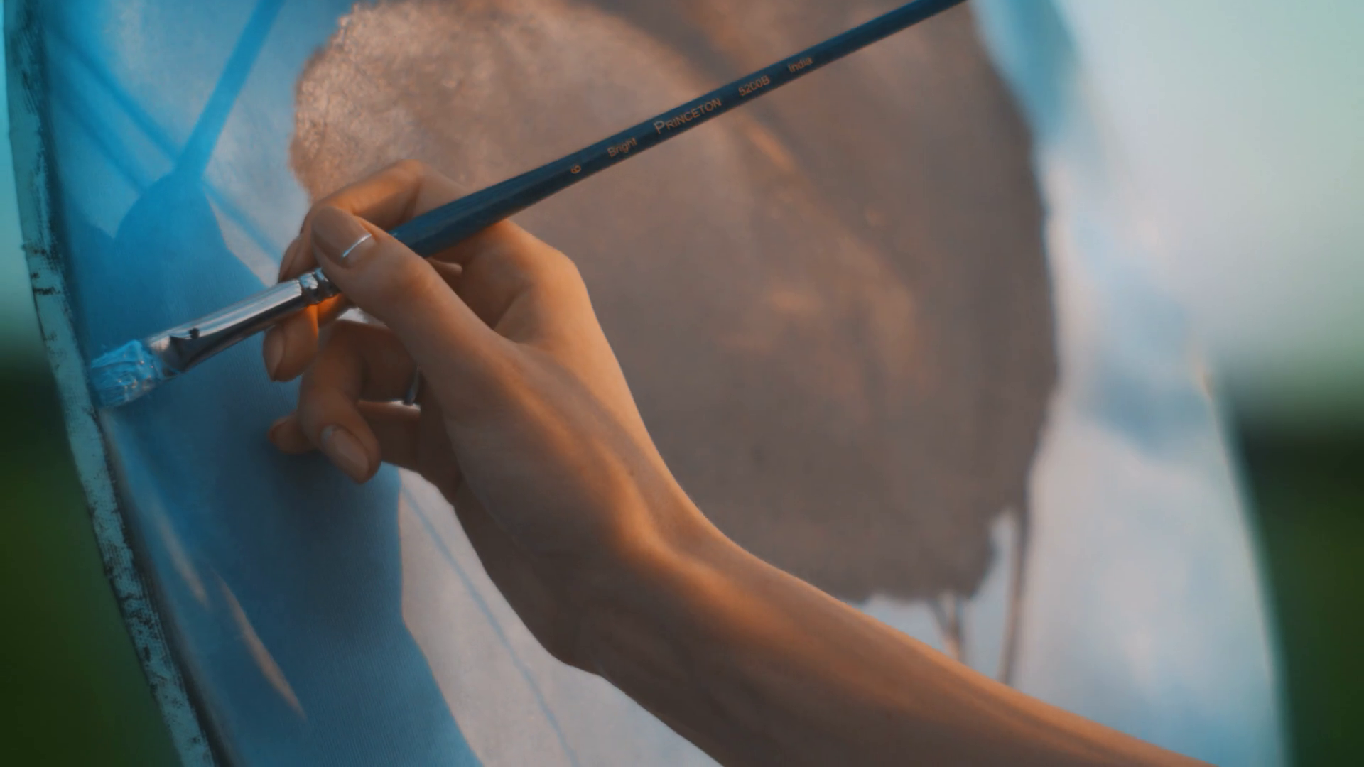 Close up woman hand with paintbrush painting on canvas. Professional