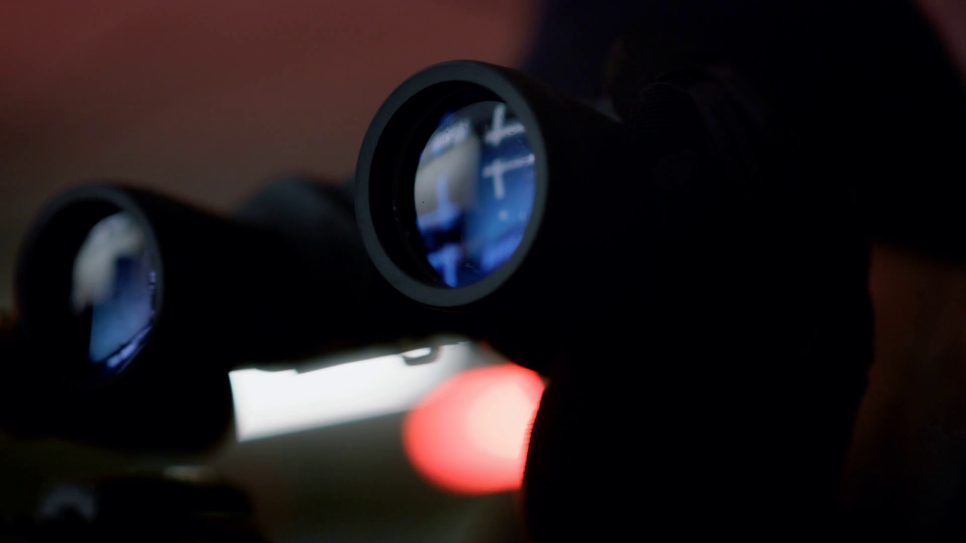 Closeup focused man using binoculars with blue lens. Portrait of