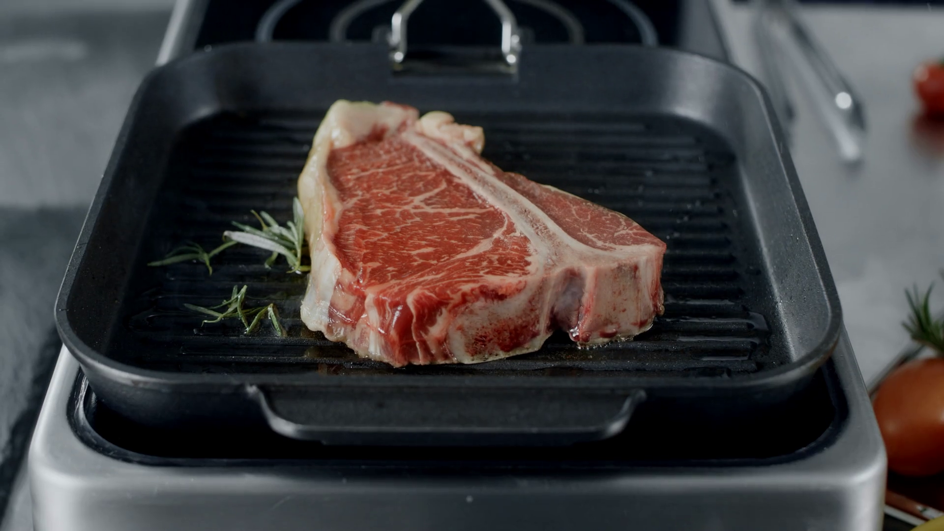Fresh steak preparing at griddle pan. Closeup beef cooking with
