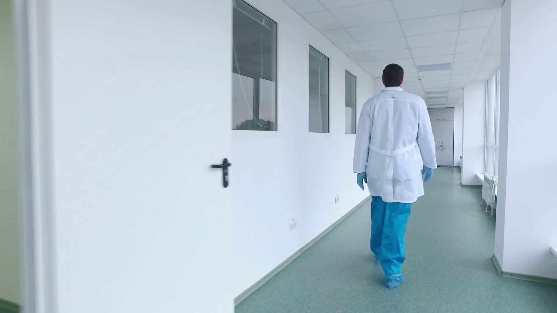 Scientist walking lab corridor. Back view of doctor walking hospital