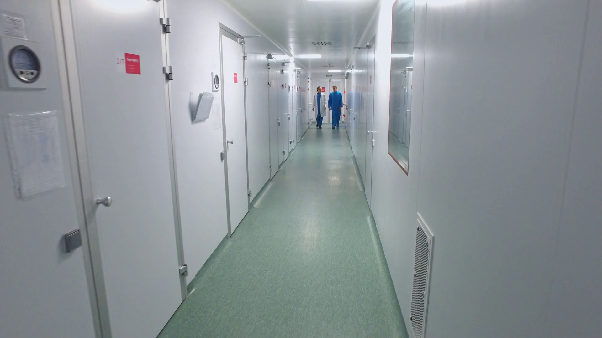 Scientists walking lab corridor. Pharmaceutical workers talking in