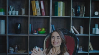 Smiling businesswoman looking at laptop screen in office. Happy business woman enjoy good news. Good business achievement. Satisfied woman clapping hands in dark cozy office. Female manager enjoy work