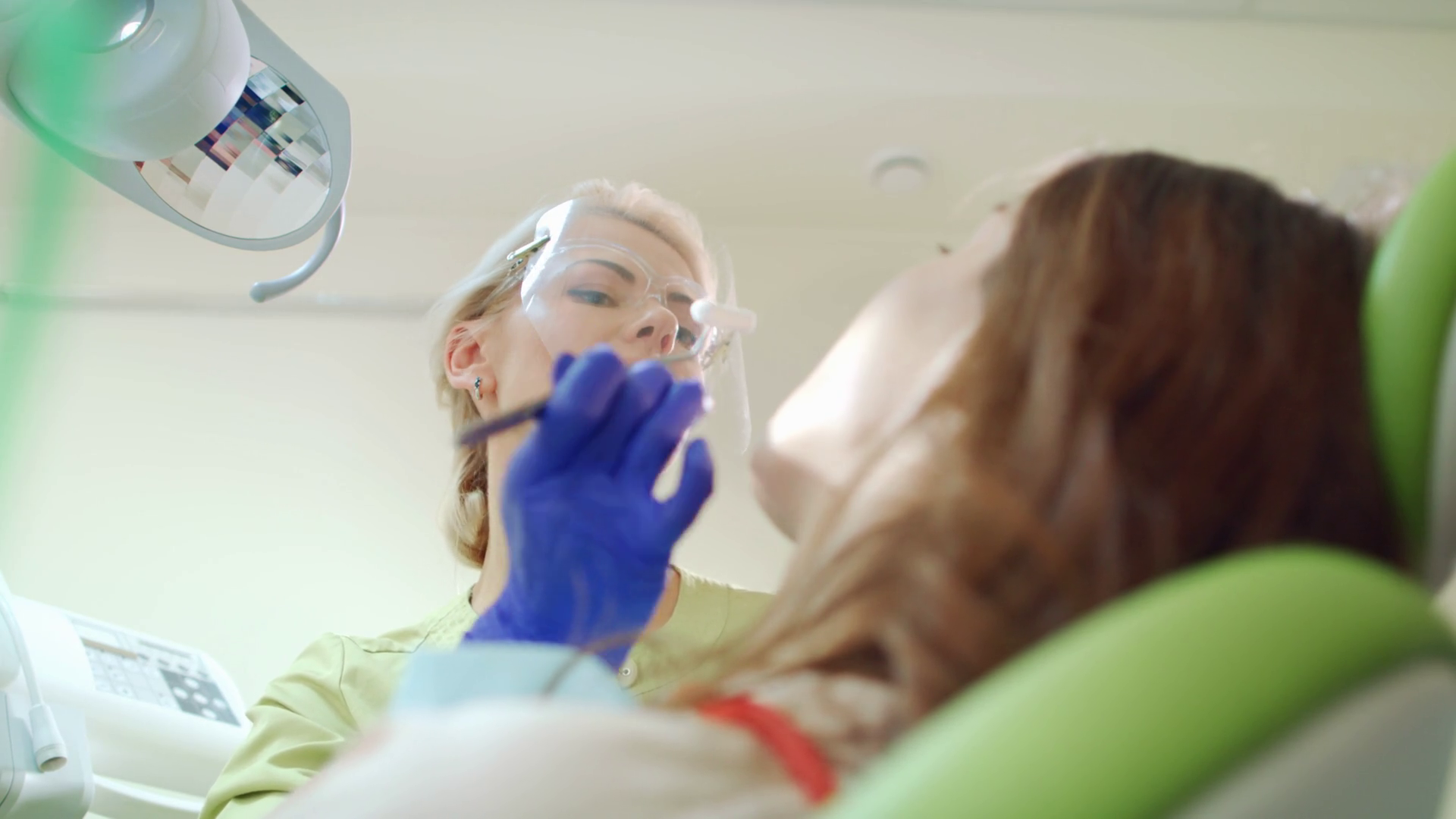 Smiling dentist working with patient in dental office. Woman dentist
