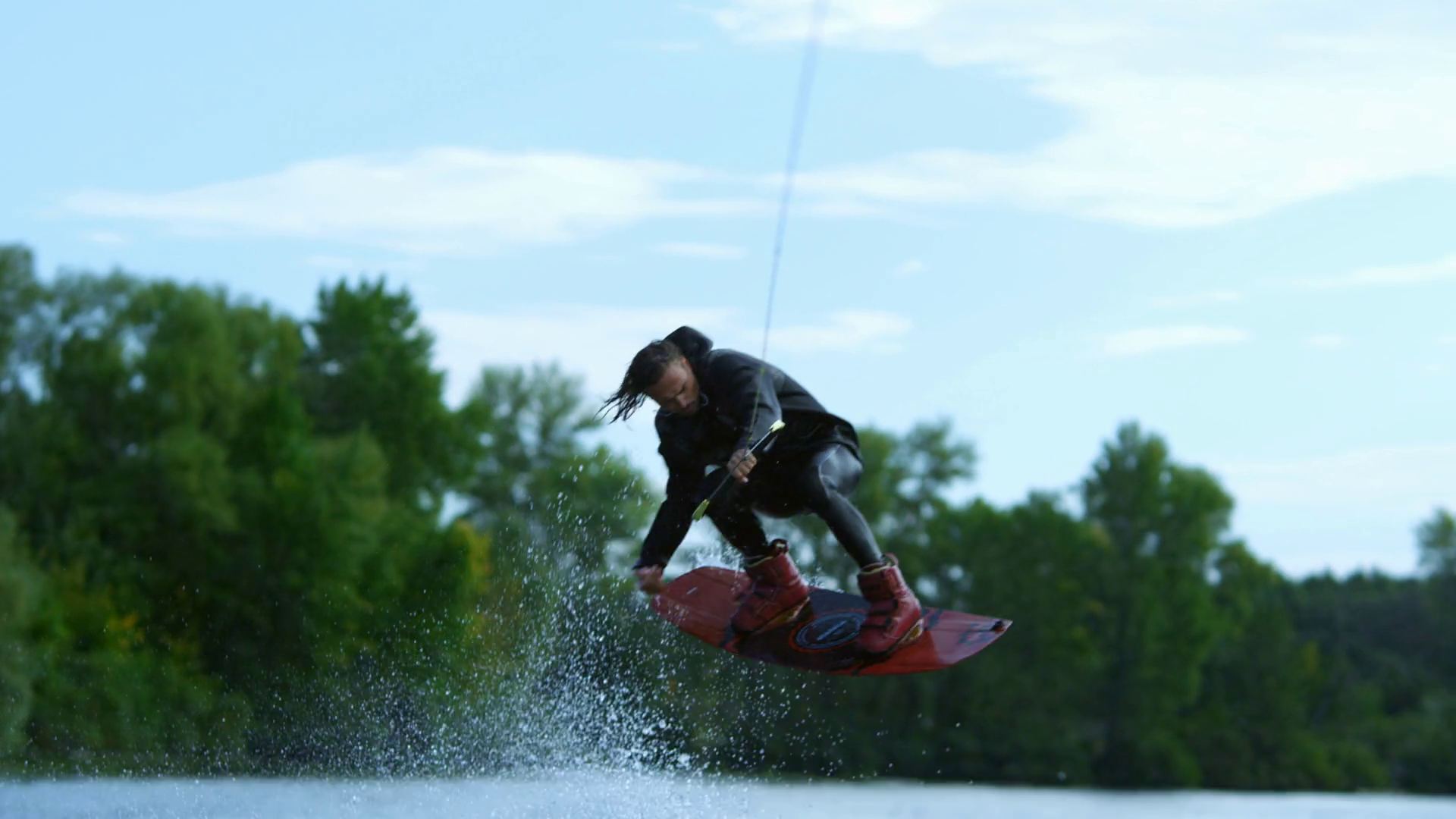 Wake board rider jumping high over water. Dangerous trick over river