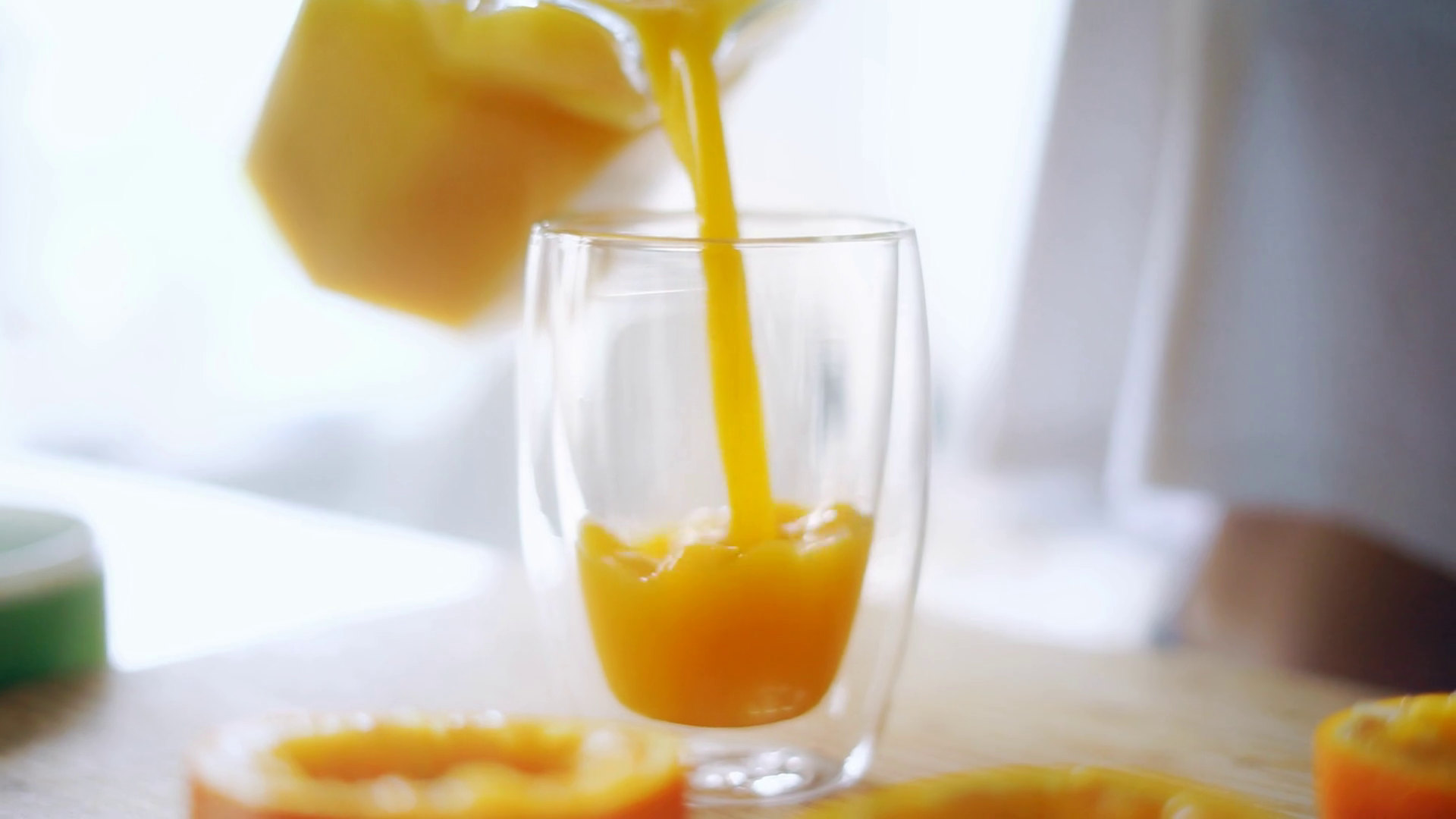 Is there some juice on the table. Close-up of a hand holding and pouring Orange Soda into a Glass. Find a Soda Drink by Color.