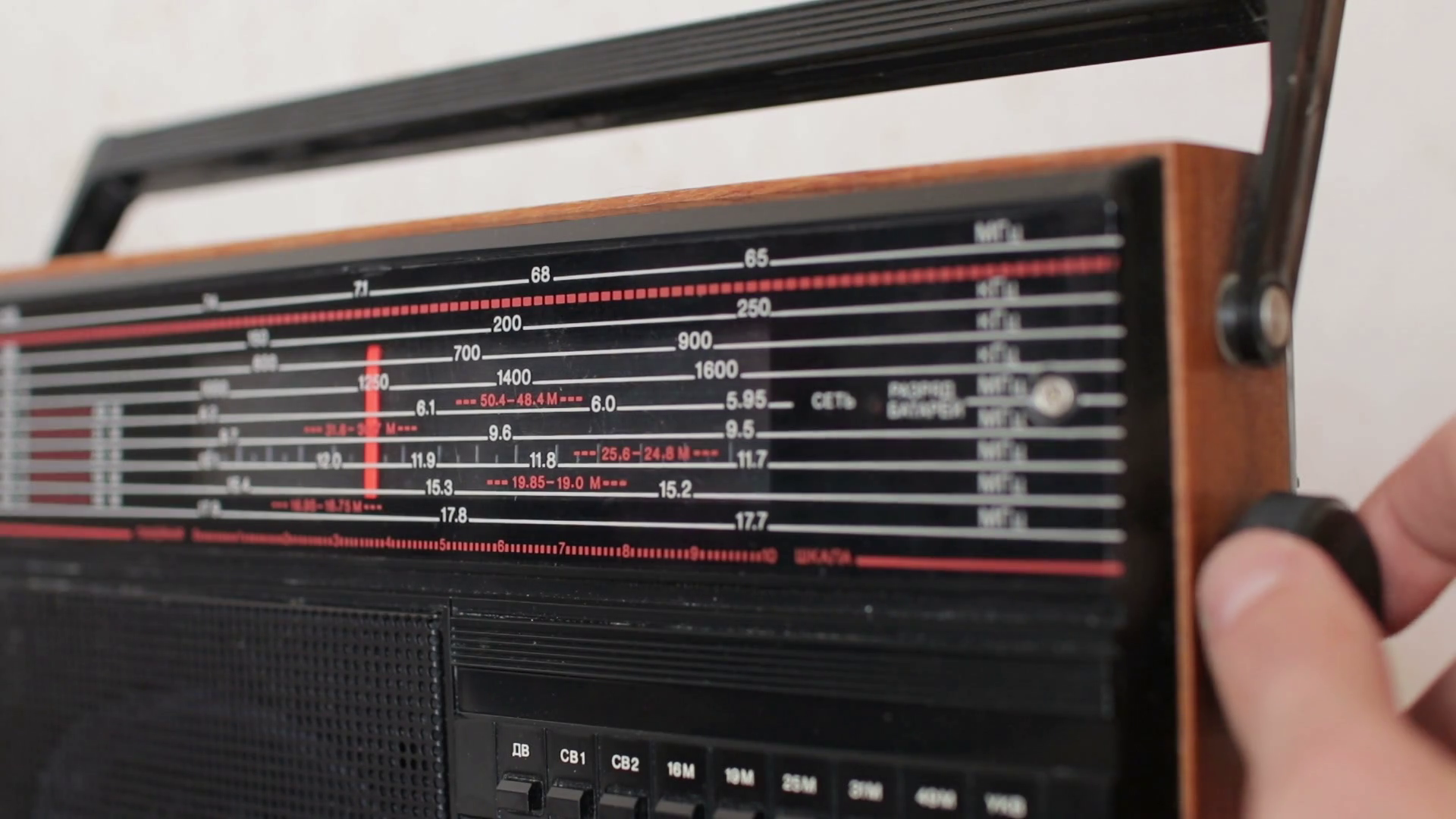 Hand tuning radio frequency knob. Changing stations old radio Stock