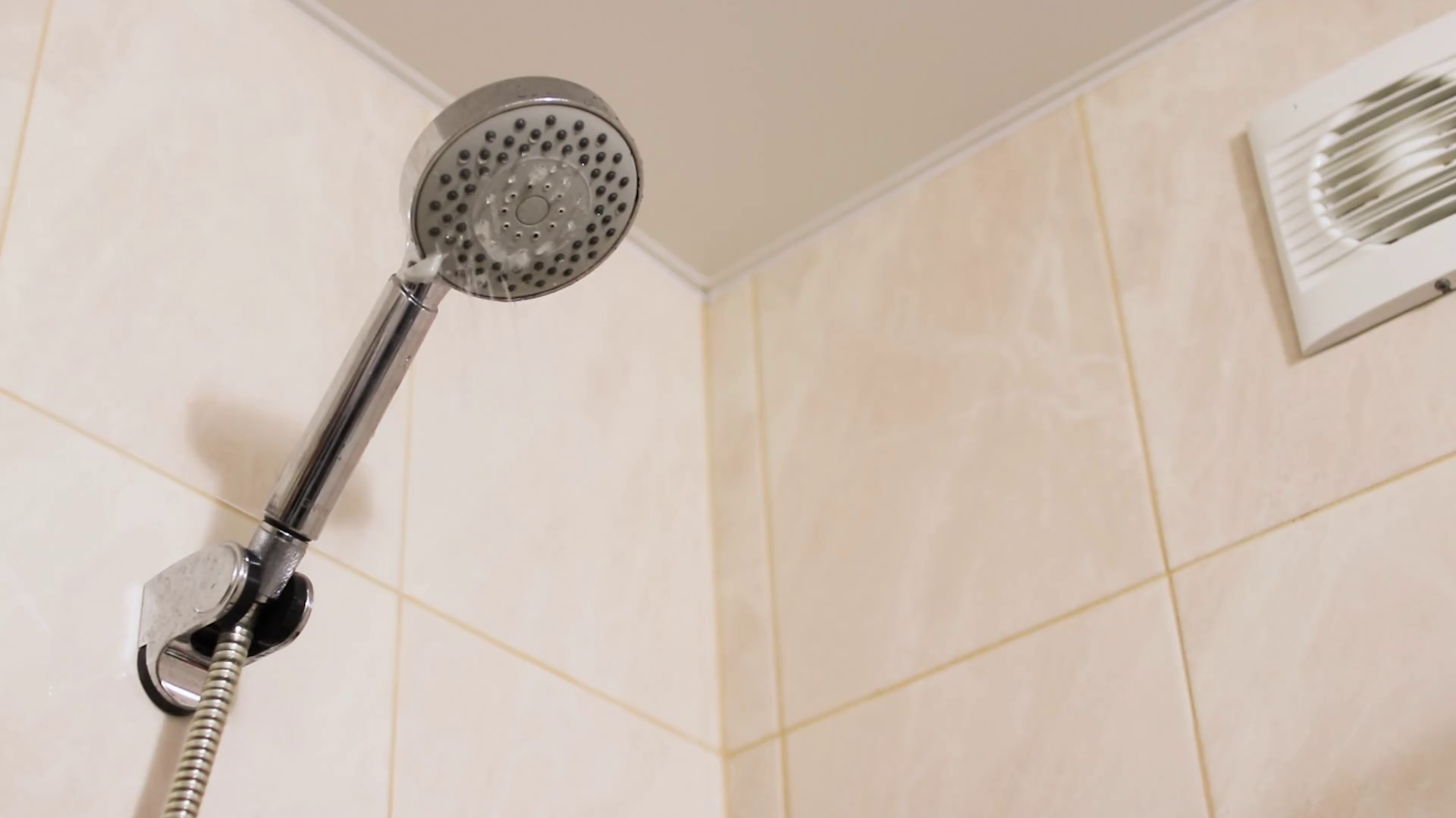 The shower in bathroom turns on, the water flows down, slow motion