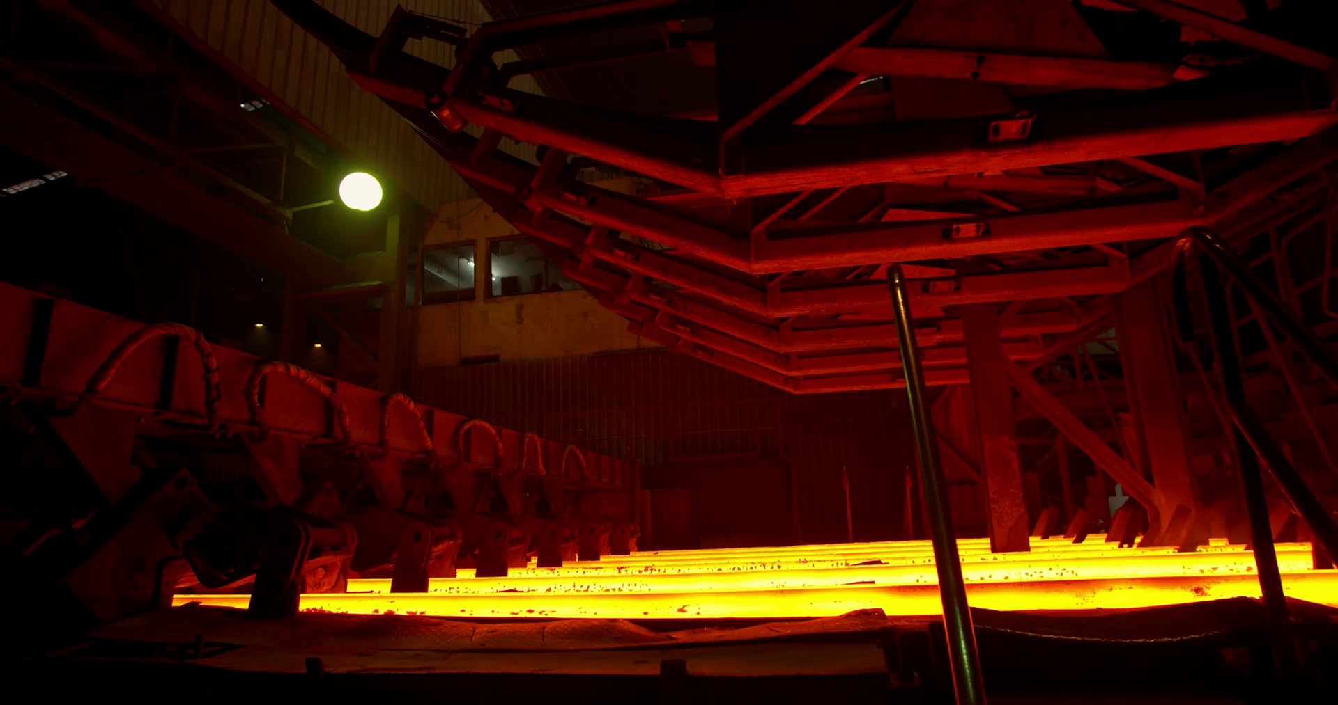 Metallurgical plant, redhot metal bar on the conveyor. Hot iron in the