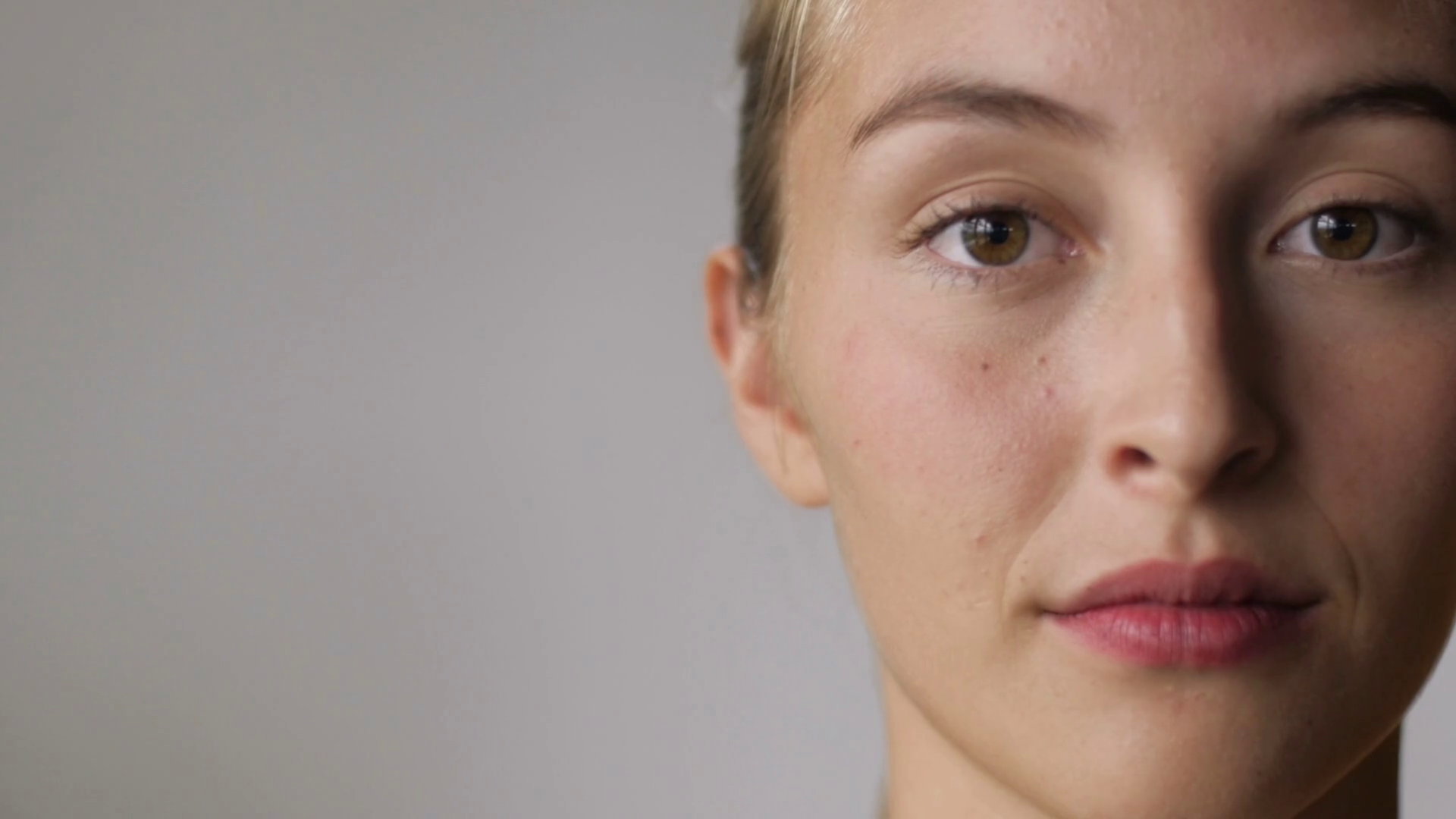 Close up of a woman turning her face to the side and smiling in slow mo