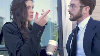 A professional businessman and millennial businesswoman shake hands and part ways after completing a deal in slow motion