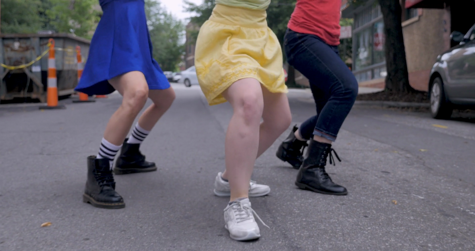 Close up of three women shuffling their feet in an urban dance in the
