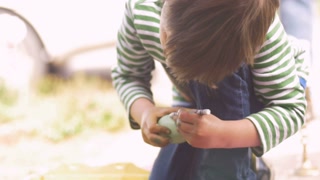 Child coloring Easter egg in slow motion for the holiday