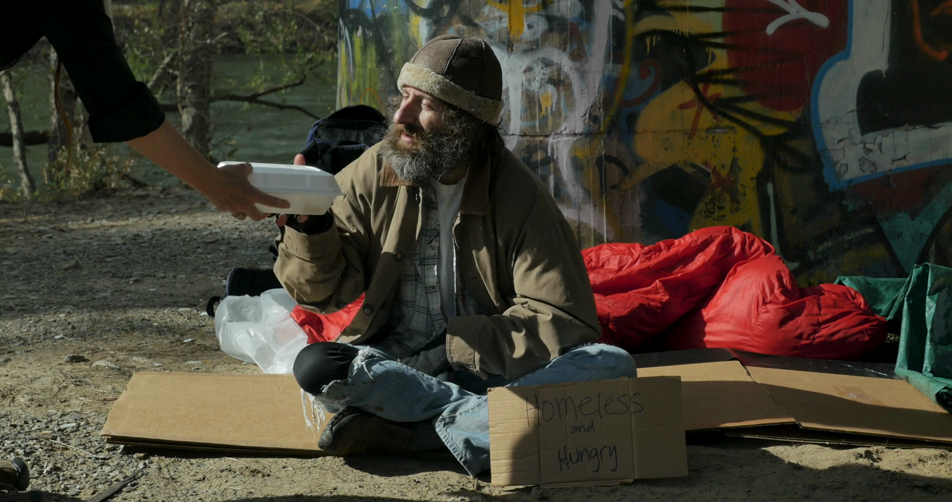 Woman Giving A Take Away Container Of Food To A Hungry Homeless Man Sitting Outside With A Homeless And Hungry Cardboard Sign Stock Video Footage Storyblocks