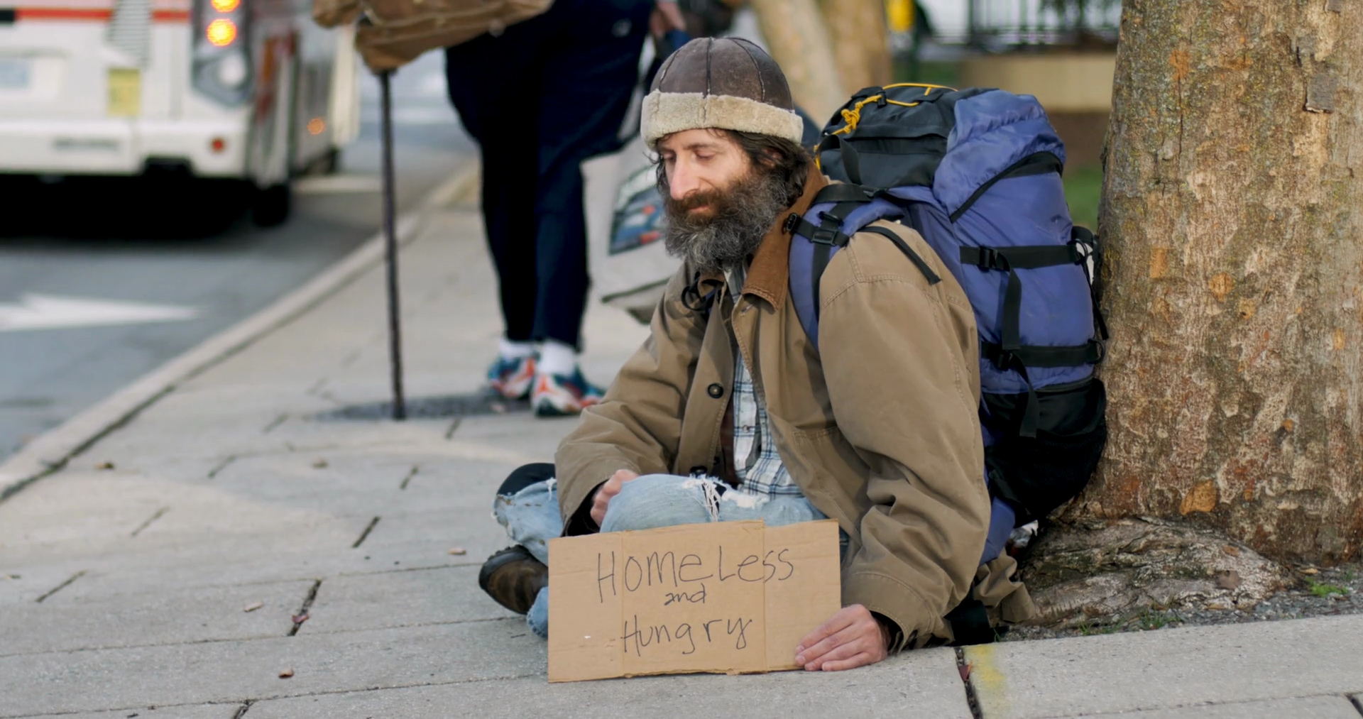 Woman With A Cane Walks By A Sad Homeless Man With A Beard Begging And Sitting On A City Sidewalk Stock Video Footage Storyblocks