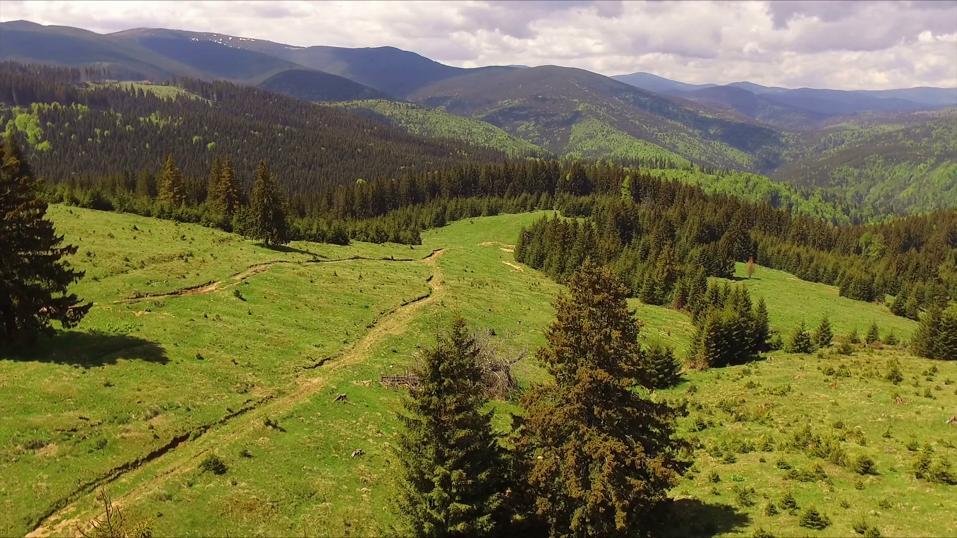 Aerial Drone Footage View: Flight over spring mountains, hills and