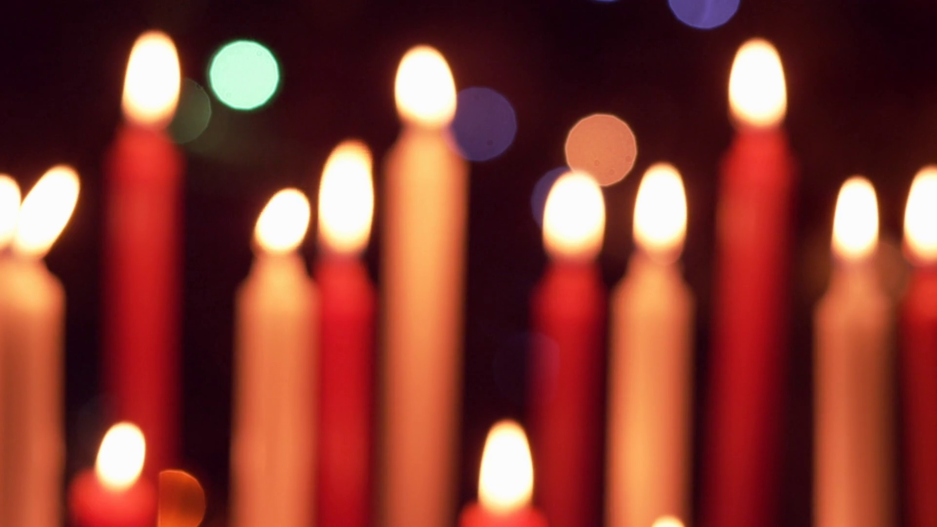 Red and white candles being blown out slowly in front of christmas