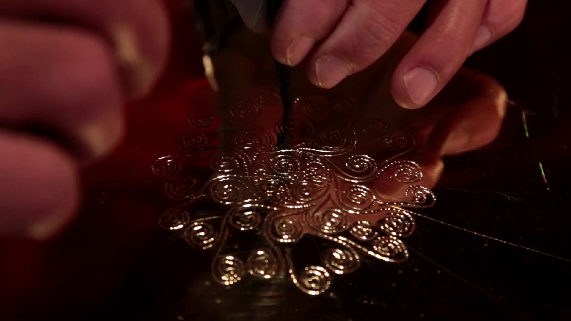 Skilled artisan etching a design into bronze plate CU closeup v2 Stock