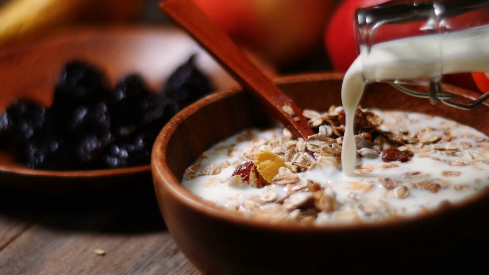 Muesli with berries and pouring milk in a bowl Stock Video Footage