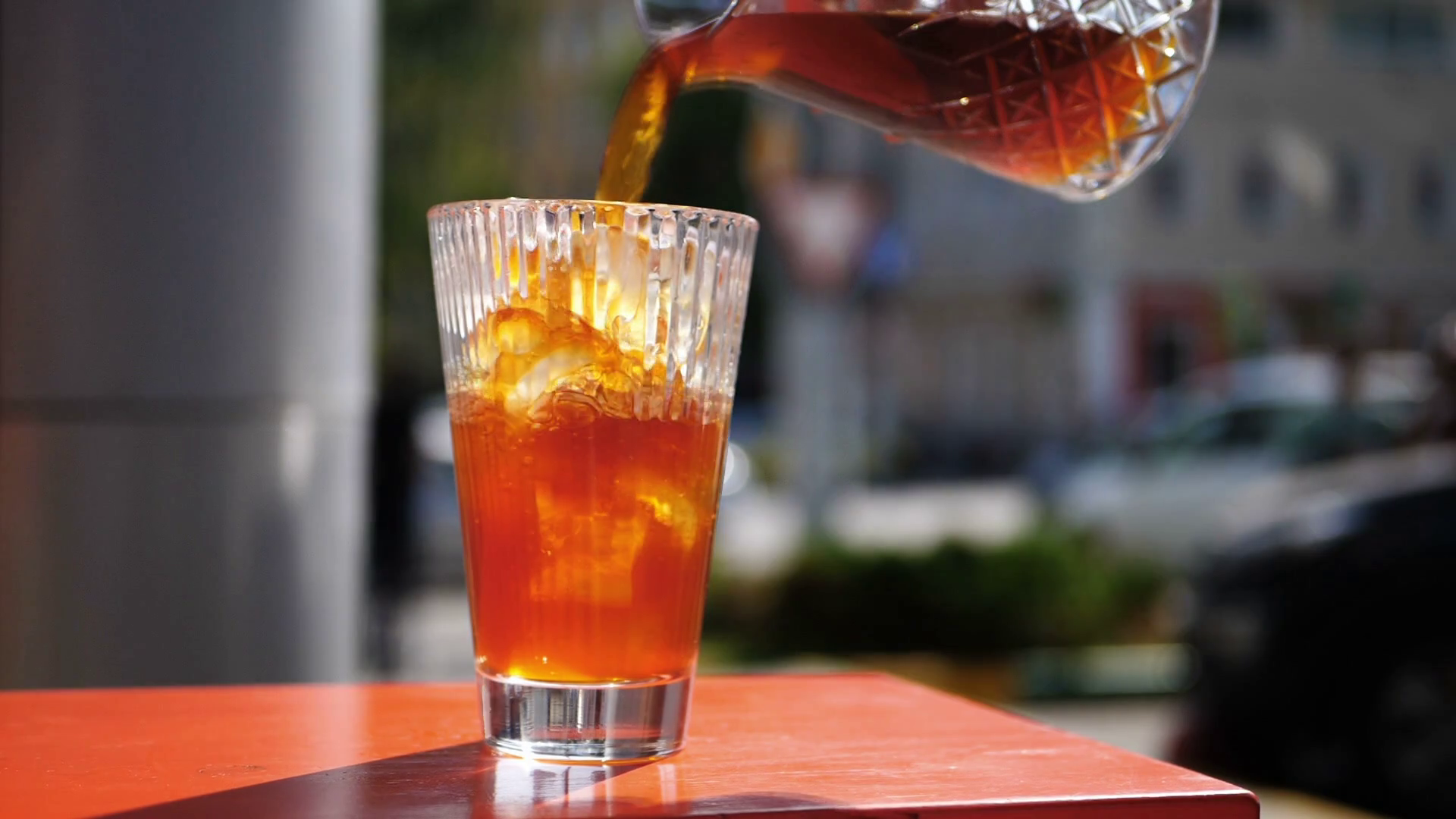 Pouring fresh coffee into glass with ice to make ice americano