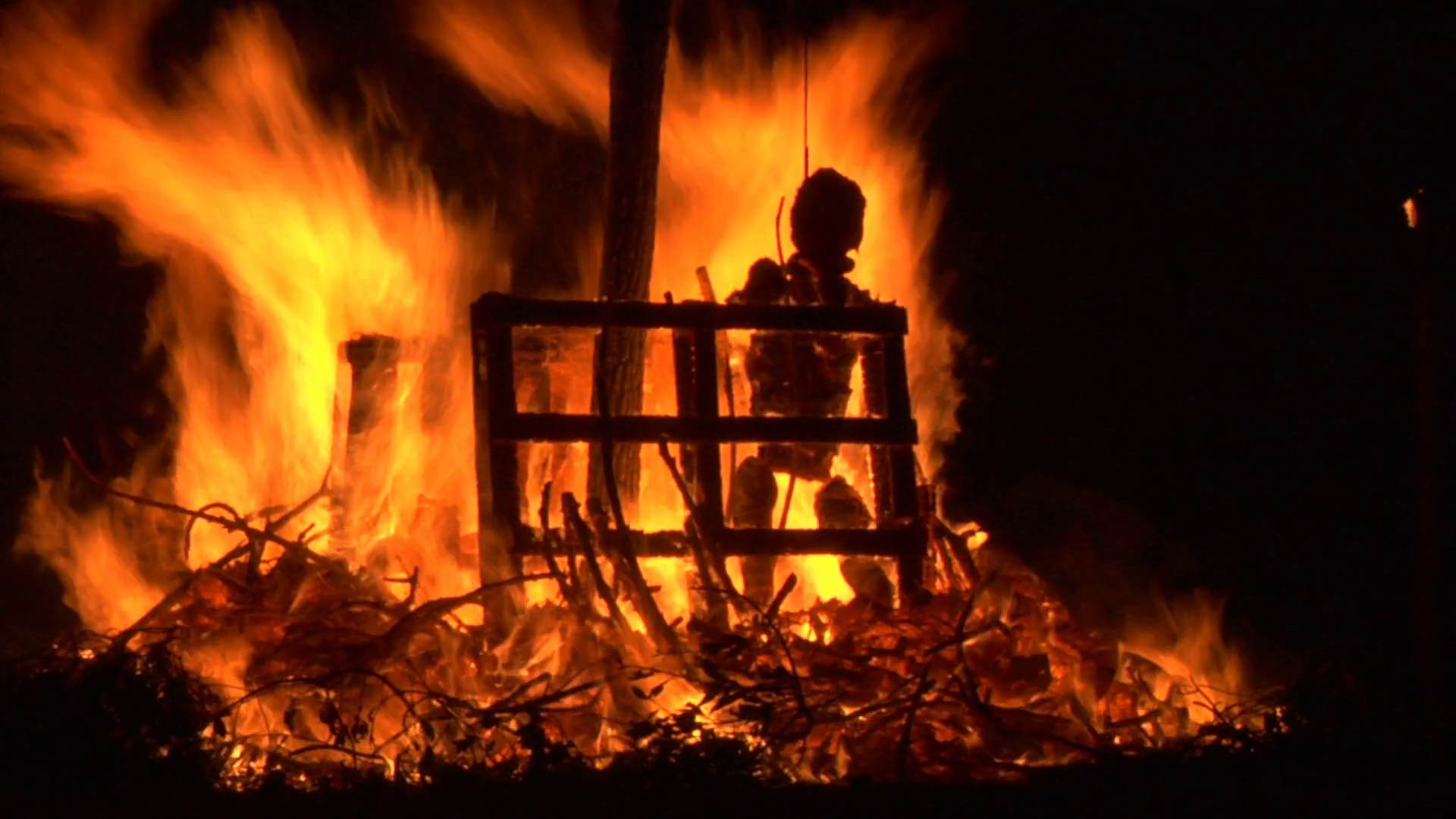 A puppet of an old witch is burnt on a bonfire Stock Video Footage 00: