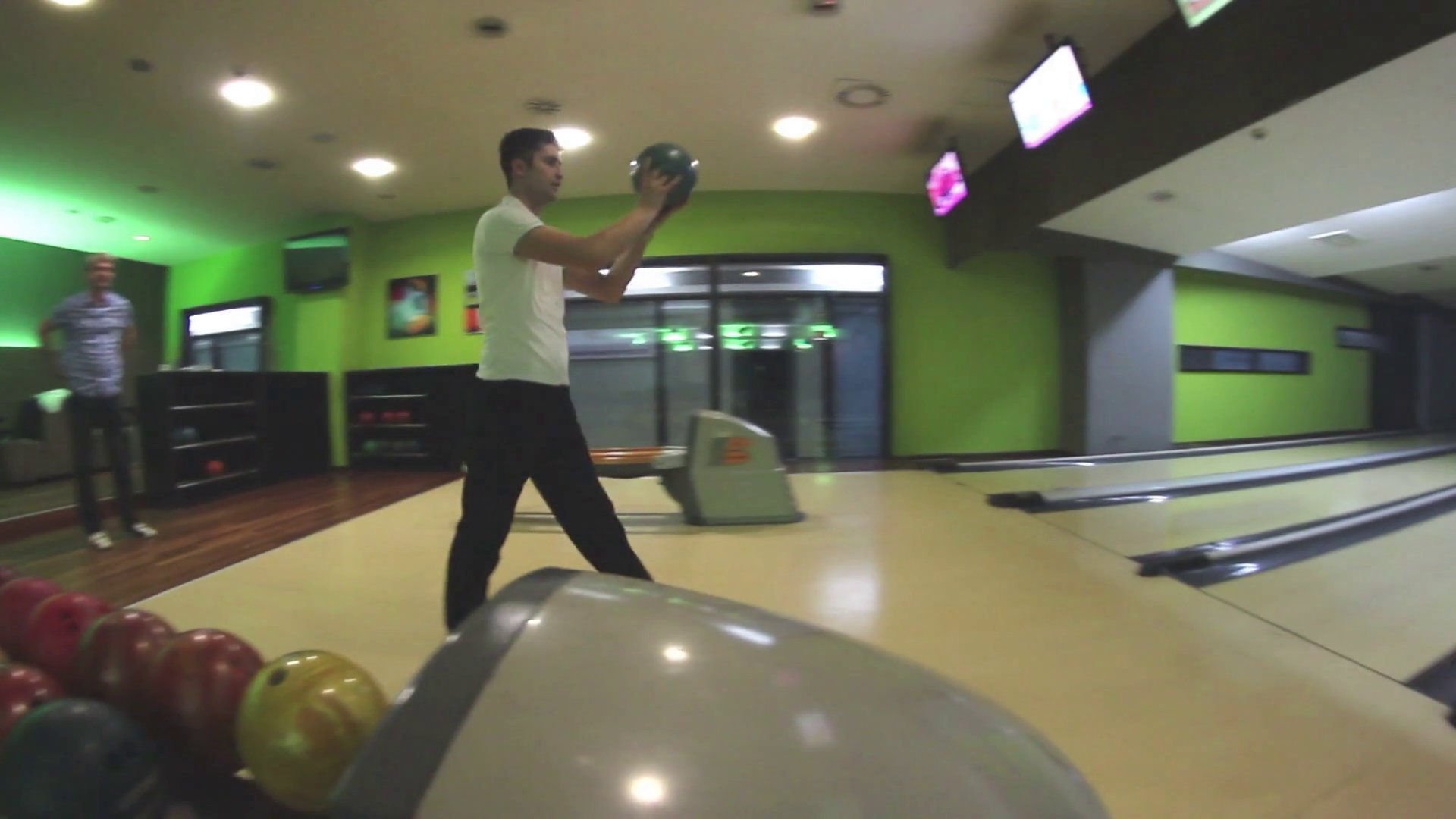 A young man throwing the bowling ball but oversteps the throwing line
