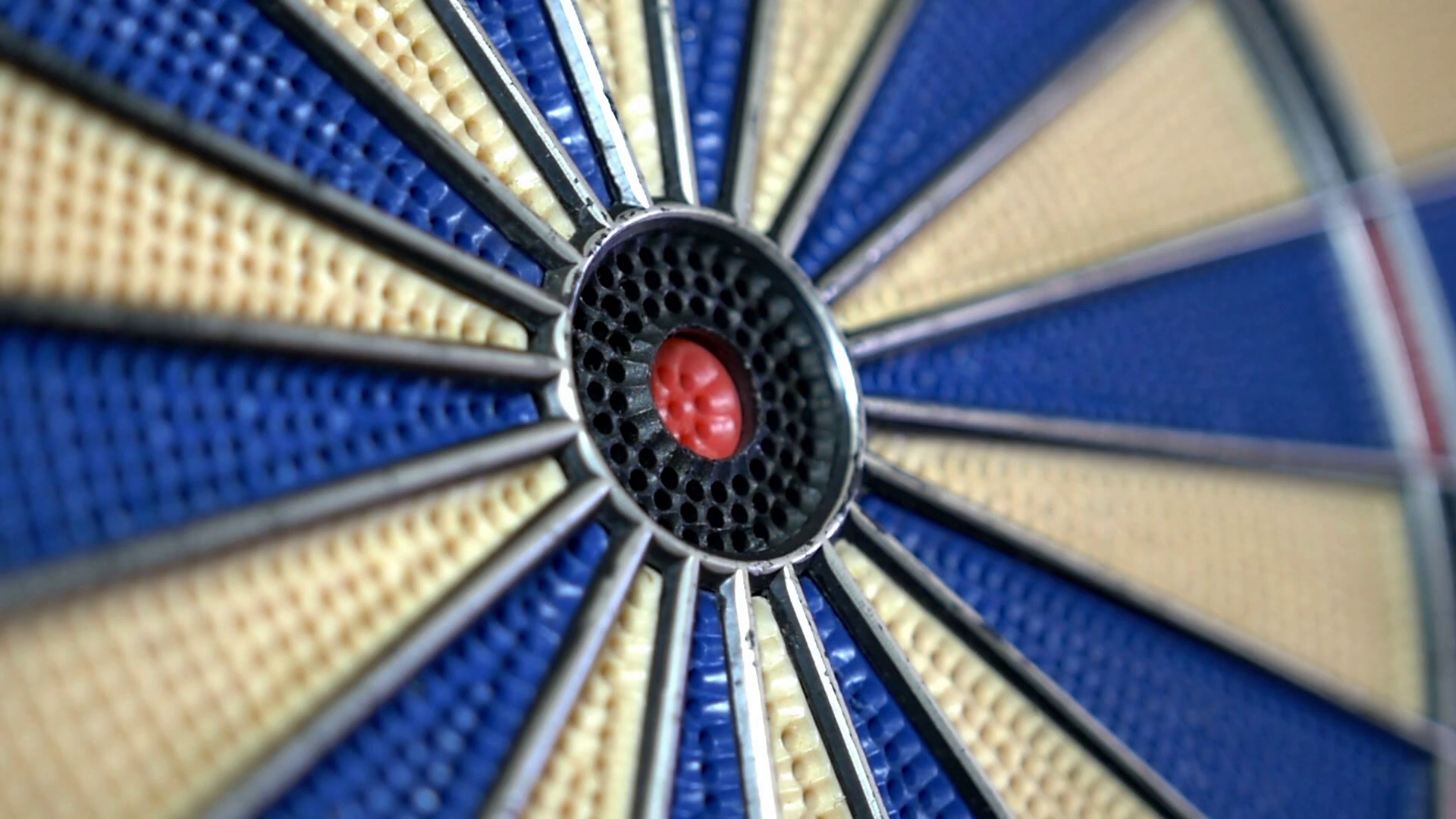 Closeup footage of a dart board and a person hitting the bullseye, in