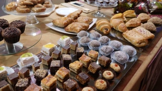 A smooth moving shot showing some sweet candies and cakes exposed on a table...