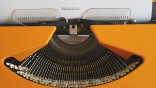 Close up footage of a person writing TERRORISM on an old typewriter, with sound