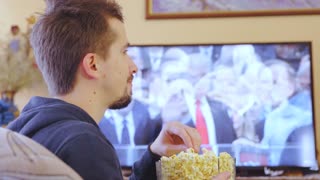 Man watch President Trump inauguration and eat popcorn smiling 4K