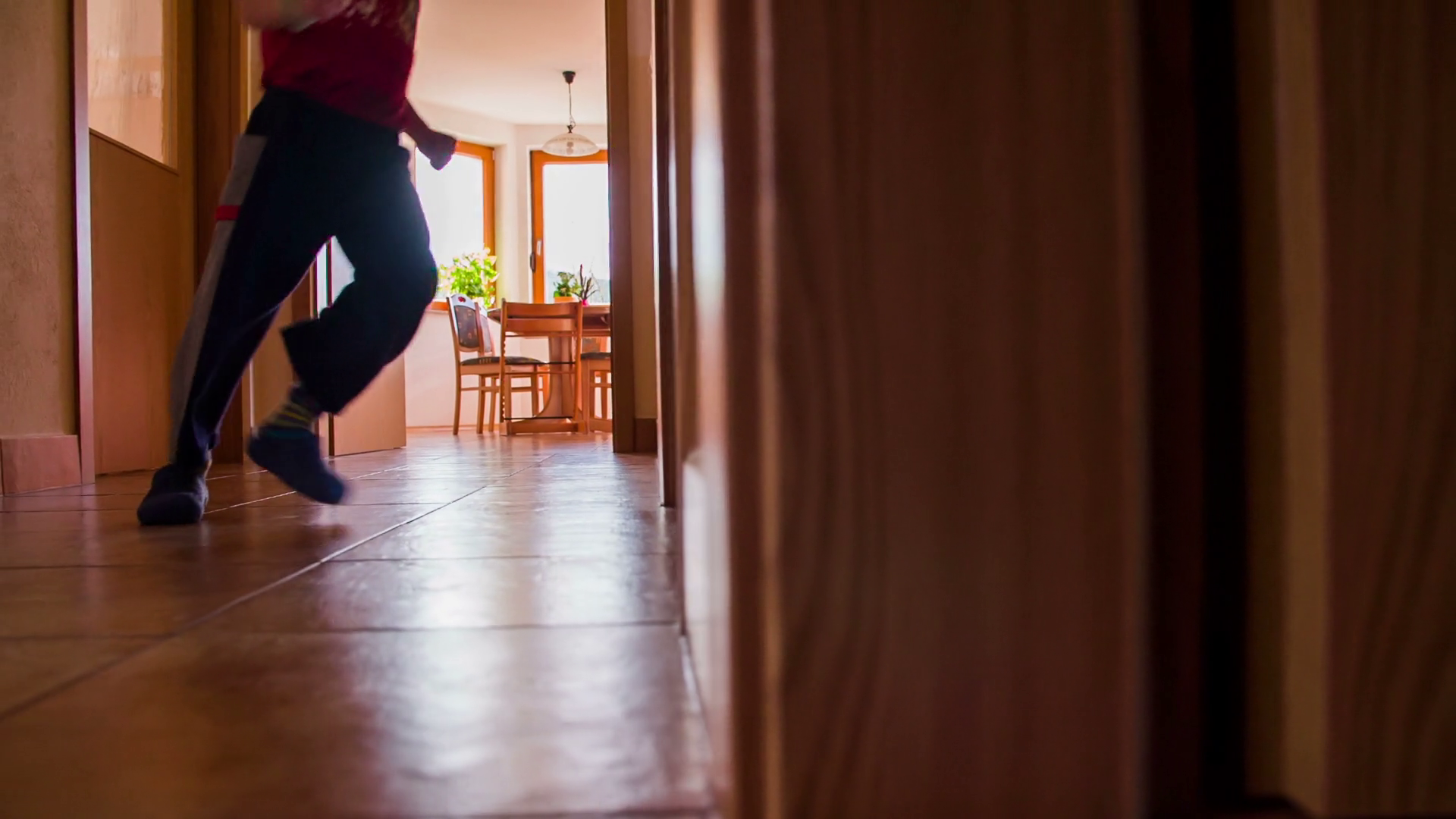 Boy run in to a room at home in slow motion. Young kid at home running from kitchen to own room