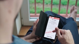Person reading XINN media fakenews source on smartphone 4K