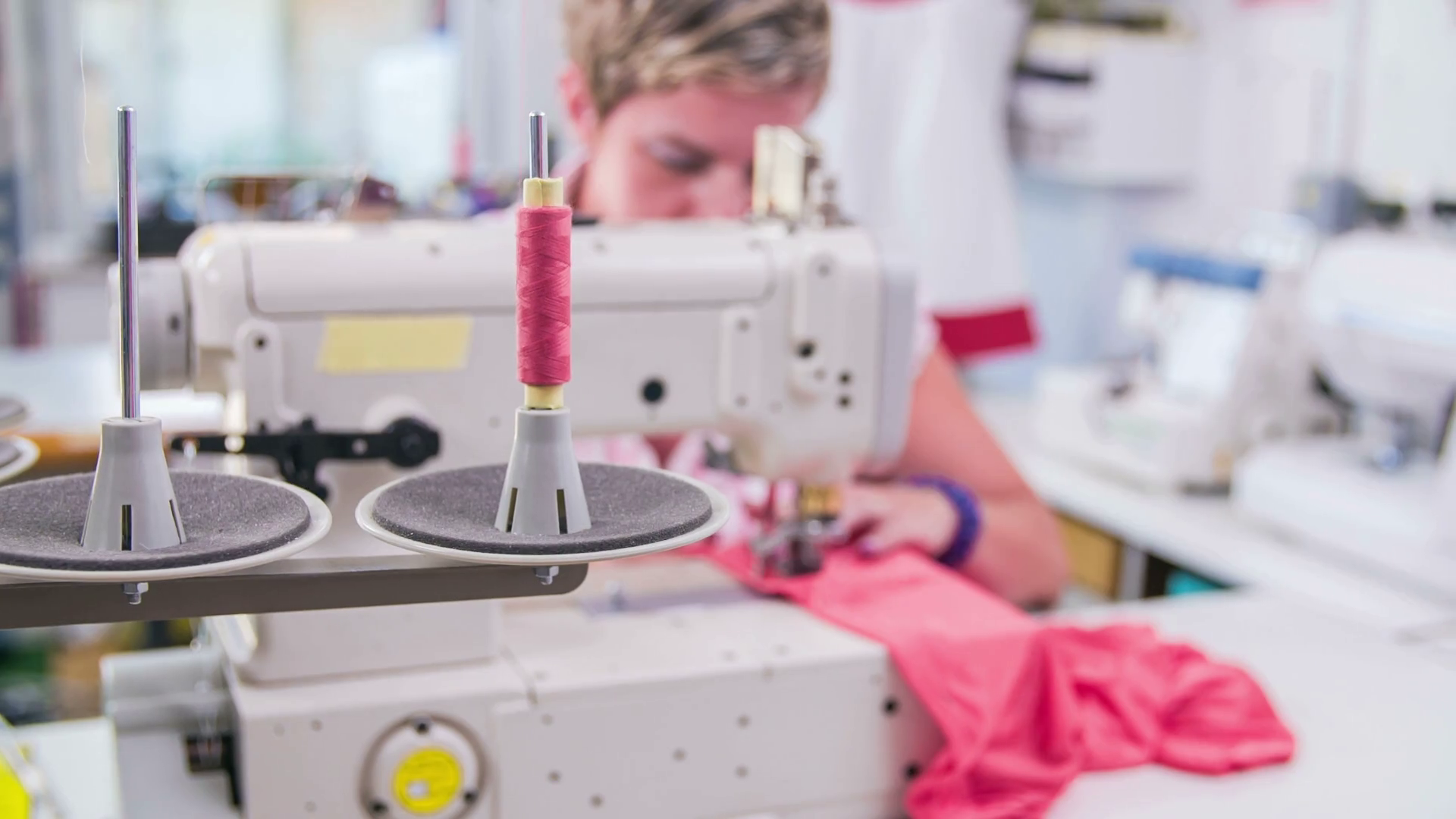 Machine pulling sewing thread while tailor working with textile