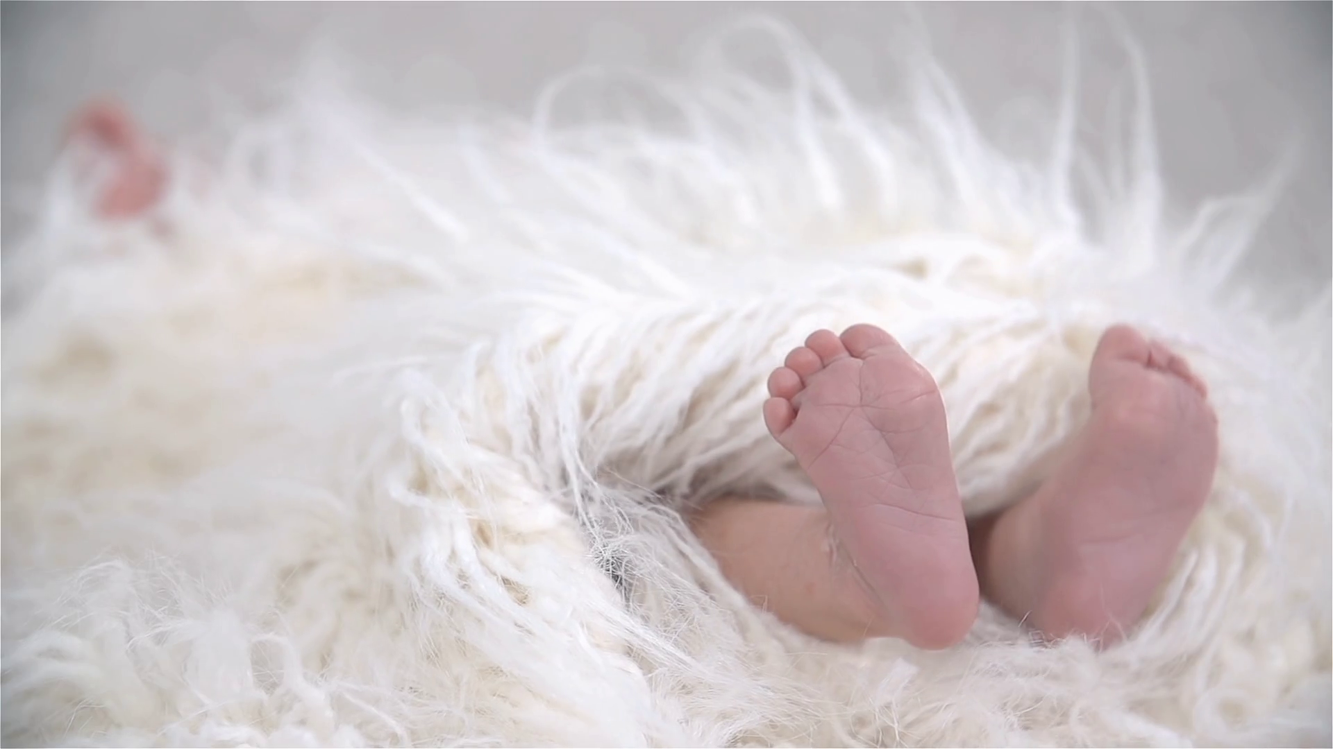 Newborn Baby Kicking under Soft Blanket in Slow Motion Stock Video