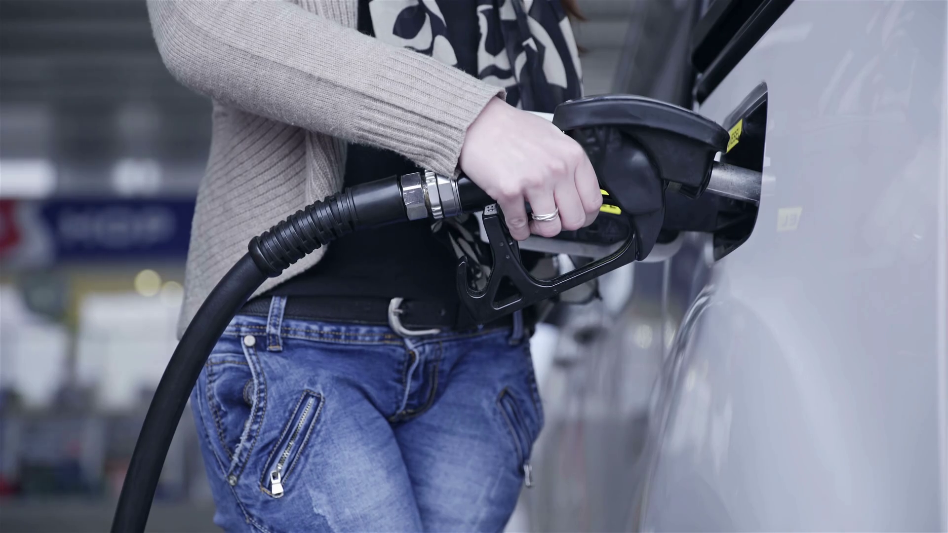 Person fueling up gasoline in car 4K. Female person hold gas pipe in to